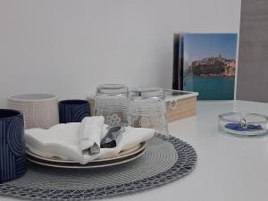 ヴィエステにあるSotto Castello Living Roomの皿とグラスと絵が置かれたテーブル
