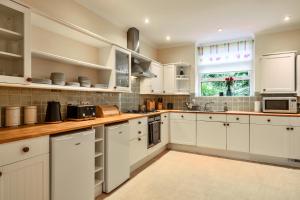 ソルカムにあるFinest Retreats - Furzehillの白いキャビネットと窓付きの白いキッチン