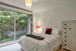 ソルカムにあるFinest Retreats - Furzehillのベッドと大きな窓のある寝室