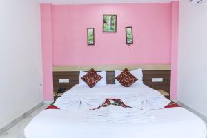 a bedroom with a bed with a pink wall at Antonio's hotel in Calangute +15 photos