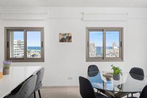 a dining room with a glass table and chairs at Downtown Sea View Penthouse in Larnaca +12 photos