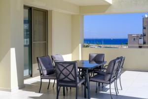 a table and chairs on a balcony with a view of the ocean at Downtown Sea View Penthouse in Larnaca