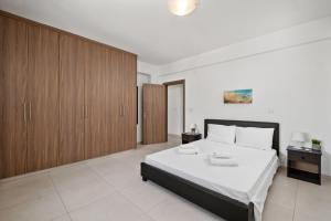 a bedroom with a large bed and wooden cabinets at Downtown Sea View Penthouse in Larnaca