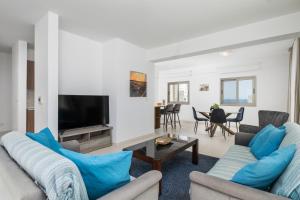 a living room with two couches and a tv at Downtown Sea View Penthouse in Larnaca