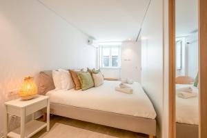 a small bedroom with a bed and a mirror at GuestReady - Condessa Flores Apartments in Lisbon +61 photos