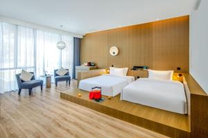 a hotel room with two beds and a chair at Wingate by Wyndham Emeishan Scenic Spot in Emeishan +44 photos