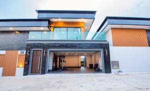 a modern house with a glass entry door at Cheeky monkey villa in Nong Prue