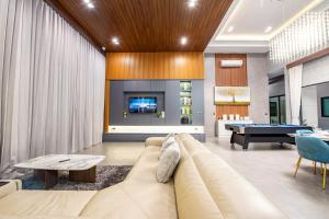 a living room with a couch and a pool table at Cheeky monkey villa in Nong Prue
