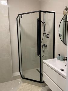 a glass shower in a bathroom with a sink at Авторский in Fontanka