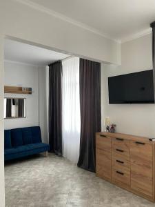 a living room with a blue couch and a tv at Авторский in Fontanka