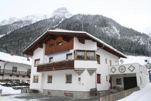 a building in the snow with mountains in the background at Haus Schimpfößl in Flirsch +8 photos