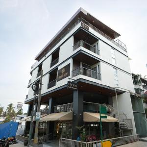 a tall white building with a clock in front of it at Nine, Boutique hotel with luxury room stay, mysore in Mysore