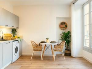 une cuisine avec une table et des chaises dans une pièce dans l'établissement Modern apartment with AC near Old Nice & Beach, à Nice 11 autres photos