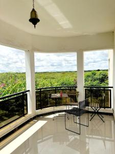 a room with a balcony with a table and chairs at Villa familiale avec piscine, barbecue et salle cinéma à proximité de Saly in Mbour