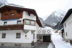 a house in the mountains with snow on the ground at Haus Schimpfößl in Flirsch