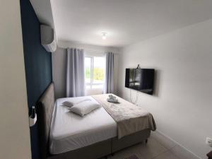 una camera da letto con un letto e una TV a parete di Apartamento 2 quartos Blumenau a 10 minutos da Vila Germânica a Blumenau Altre 48 foto