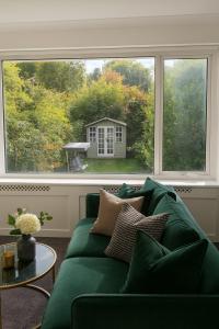 a green couch in a living room with a large window at Comfortable 3 bed in Winchester - Parking in Winchester
