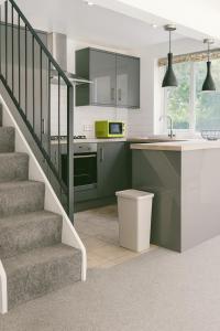 a kitchen with green cabinets and a staircase at Comfortable 3 bed in Winchester - Parking in Winchester