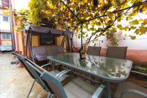 a table and chairs sitting under a tree at Central 2-Bedroom House with Shared Courtyard near Old Town Bucharest in Bucharest