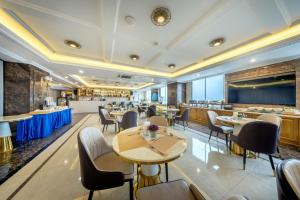 a restaurant with tables and chairs and a bar at ST Hotel Wattay Airport in Vientiane