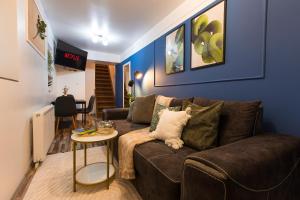 a living room with a brown couch and a table at Central 2-Bedroom House with Shared Courtyard near Old Town Bucharest in Bucharest