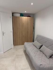 a bedroom with a bed and a wooden cabinet at Studio in Saint-Cloud in Saint-Cloud