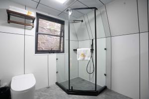 baño con ducha, aseo y ventana en VERDANT HAVEN, en Jiezi Ancient Town