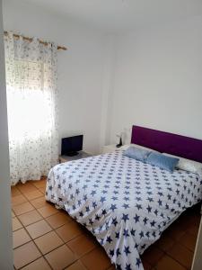 Un dormitorio con una cama con un edredón azul y blanco. en Apartamento Islantilla Club, en Islantilla 15 fotos más