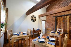 a dining room with wooden tables and chairs and a brick wall at Old Field Barn Luxury B & B in Attleborough