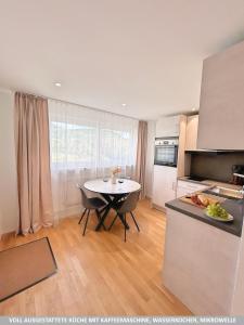 a kitchen with a table and a dining room at Basilisk Homes - in Grenzach-Wyhlen bei Basel - 4 x Moderne Fewos je 1bis2, 1bis4 oder 1bis6 Pers mit Küche und Balkon oder Terrasse - Parkplätze vorhanden in Grenzach-Wyhlen