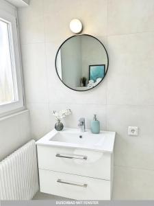 a bathroom with a white sink and a mirror at Basilisk Homes - in Grenzach-Wyhlen bei Basel - 4 x Moderne Fewos je 1bis2, 1bis4 oder 1bis6 Pers mit Küche und Balkon oder Terrasse - Parkplätze vorhanden in Grenzach-Wyhlen +5 photos