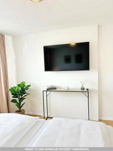 a bedroom with a bed and a tv on the wall at Basilisk Homes - in Grenzach-Wyhlen bei Basel - 4 x Moderne Fewos je 1bis2, 1bis4 oder 1bis6 Pers mit Küche und Balkon oder Terrasse - Parkplätze vorhanden in Grenzach-Wyhlen