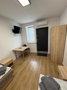 a room with a desk and a table and a door at Herman Pokoje - nr 8 in Hermanowice
