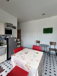 a kitchen with a table and red chairs in a kitchen at Merit Courtyard Suvarnabhumi House in Lat Krabang