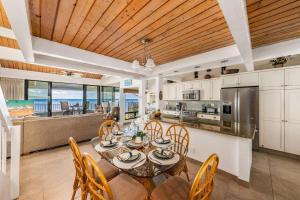 a kitchen and dining room with a table and chairs at Kahana Village 33 · KHV 33 Oceanfront 2BD Villa Spectacular Ocea in Kahana