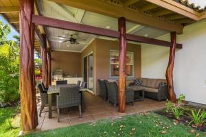 un patio cubierto con mesa y sillas en Fairways Mauna Lani 1406 condo, en Waikoloa
