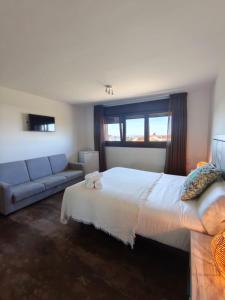 a bedroom with a large bed and a couch at Hotel Rural O Salazón in Cambados