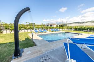 カンポフェリーチェ・ディ・ロッチェッラにあるVilla Arvilla with Private POOLのリゾートの隣にあるスイミングプール(青いラウンジチェア付)