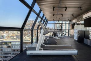 a gym with a treadmill in a large room with windows at Four Points by Sheraton Santiago in Santiago