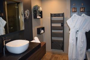a bathroom with a sink and a large mirror at Le Trophée Boutique Hôtel Spa- La Loggia Appart'hôtel in Deauville +59 photos