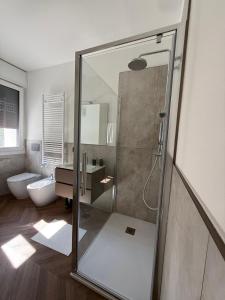 a bathroom with a shower with a sink and a toilet at Appartamento Aurora in Pordenone