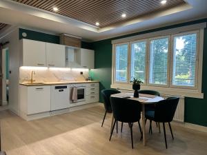 a kitchen with green walls and a table and chairs at Hidden gem near Fiskars and Billnäs in Raseborg