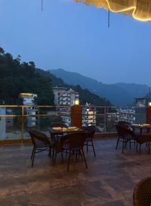 a patio with tables and chairs on a roof at Hotel the shore by Trindra Hospitality in Rishīkesh