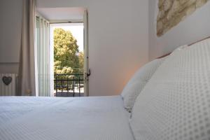Un dormitorio con una cama blanca y una ventana. en Casa Vacanza "Marinella", en Sulmona