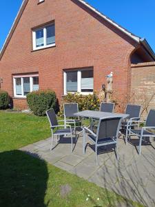 a table and chairs in front of a brick building at Ferienhaus Kornew OG in Dornum