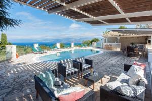 a patio with a pool with chairs and a table at Thea Estate in Kelliá