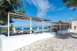 an outdoor patio with a pergola and patio furniture at Thea Estate in Kelliá