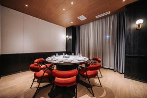 a conference room with a table and red chairs at Ace Hotel Keketuohai in Temeke