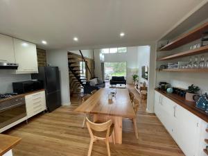 a kitchen and dining room with a wooden table at Dusky Waters - Modern & Spacious - EV charger in Sanctuary Point
