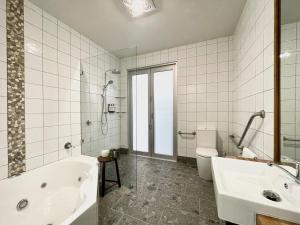 a bathroom with a tub and a sink and a toilet at Dusky Waters - Modern & Spacious - EV charger in Sanctuary Point +25 photos